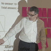 Tony Quinlan explaining how to interpret SenseMaker signifiers. The pink objects behind him are the micro-narratives we produced during the exercise, on ‘super-sticky’ Post-It notes. Photo Conrad Taylor.